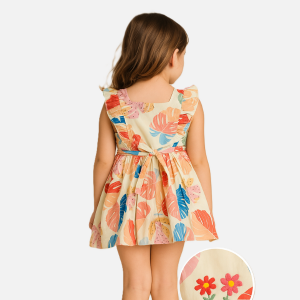 Back view of a toddler girl in a tropical cotton dress with waist tie and embroidered floral detailing